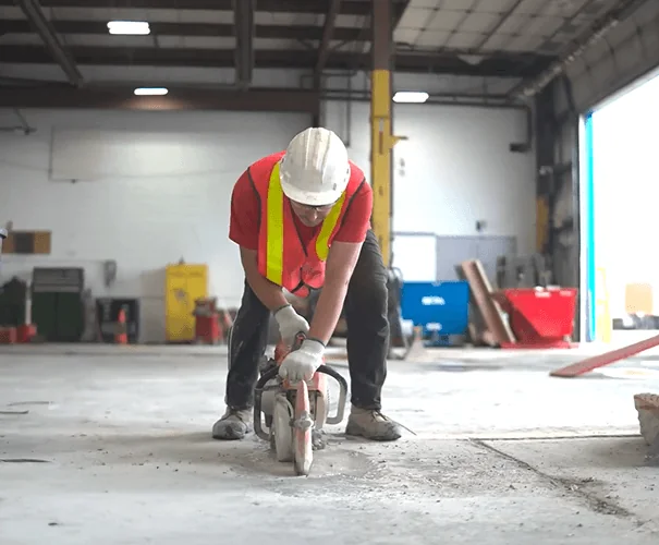 Worker cutting a concrete floor with a power saw