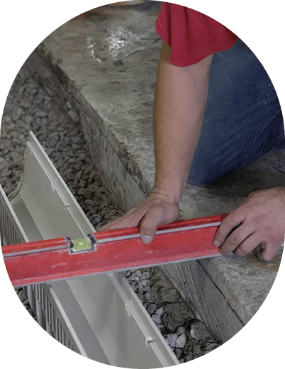 Spirit level across a drain channel during installation