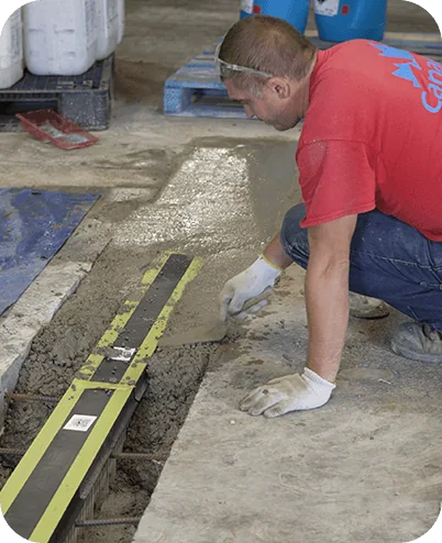 Installer aligning a floor drain with a long spirit level