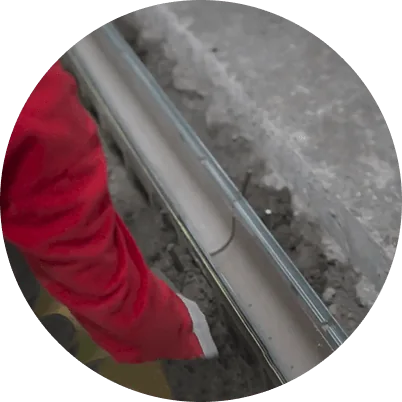 Metal drain channel positioned inside an excavated floor trench