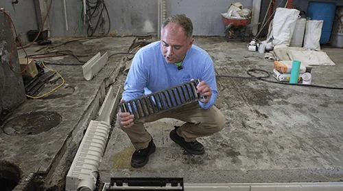 Installer inspecting a removable trench drain grate